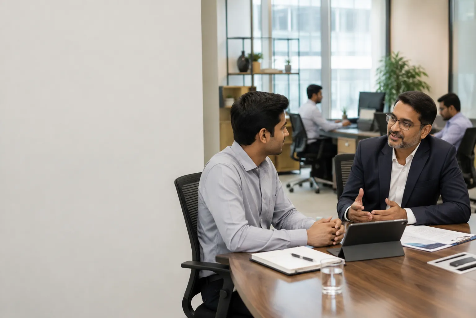 iDONE Office Team Discussion Colleagues discussing workforce data at an office desk representing iDONE HR analytics