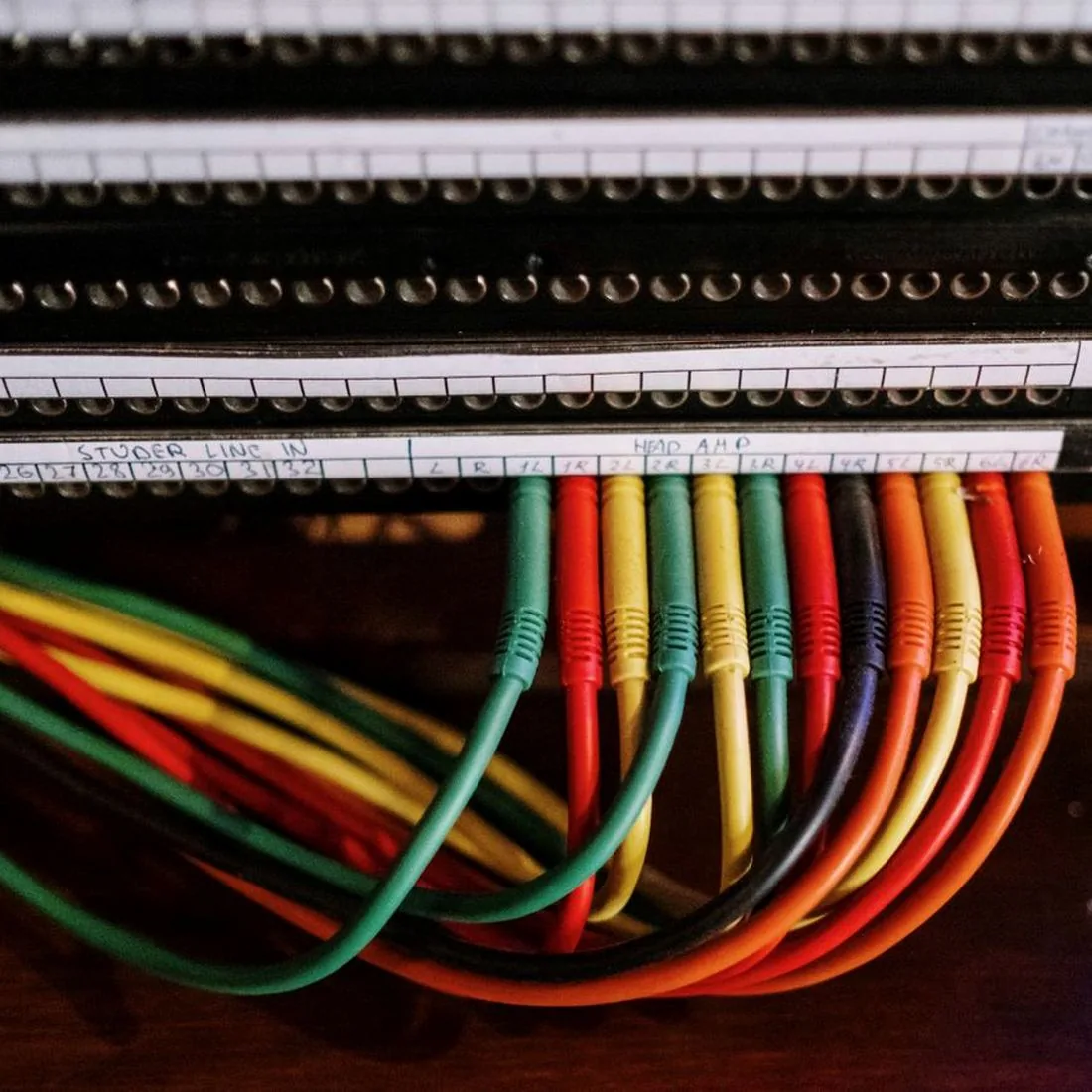 Colourful patch cords plugged into a labelled patch panel in a rack