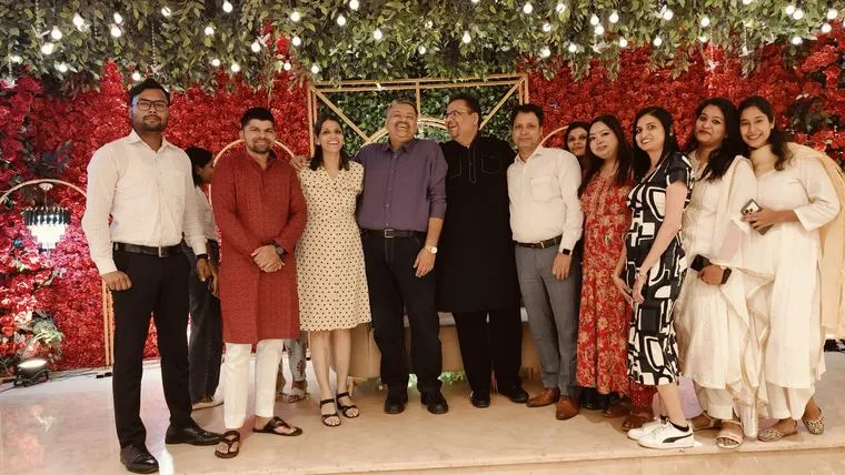 The team at a festive event with a floral backdrop