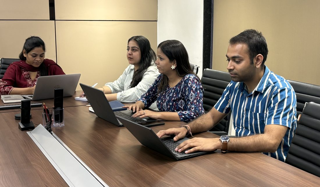 The team in a conference room meeting with laptops