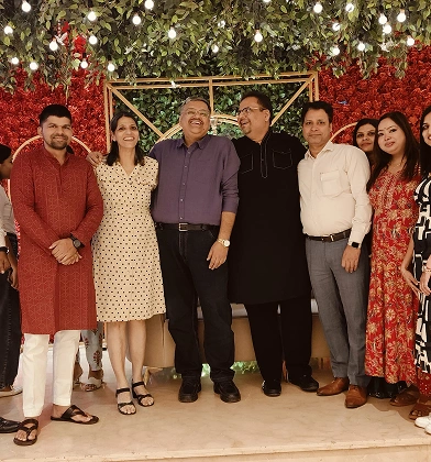 Team posing at a festive celebration with floral decor